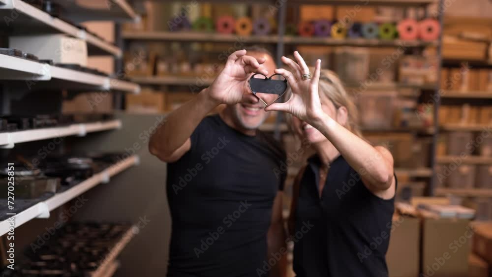 couple of working class labor holding a heart shape template in fabric textile factory fashion designer stylist couple of working class labor holding a heart shape template in fabric textile factory fashion designer stylist