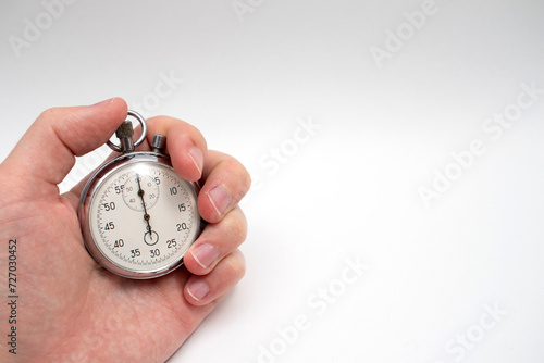 Hand stopping a stopwatch button. Stopwatch hold in hand.