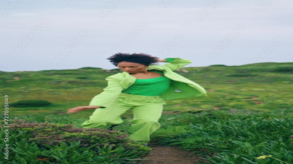 Passionate girl dancer performing contemporary style at field cloudy vertical