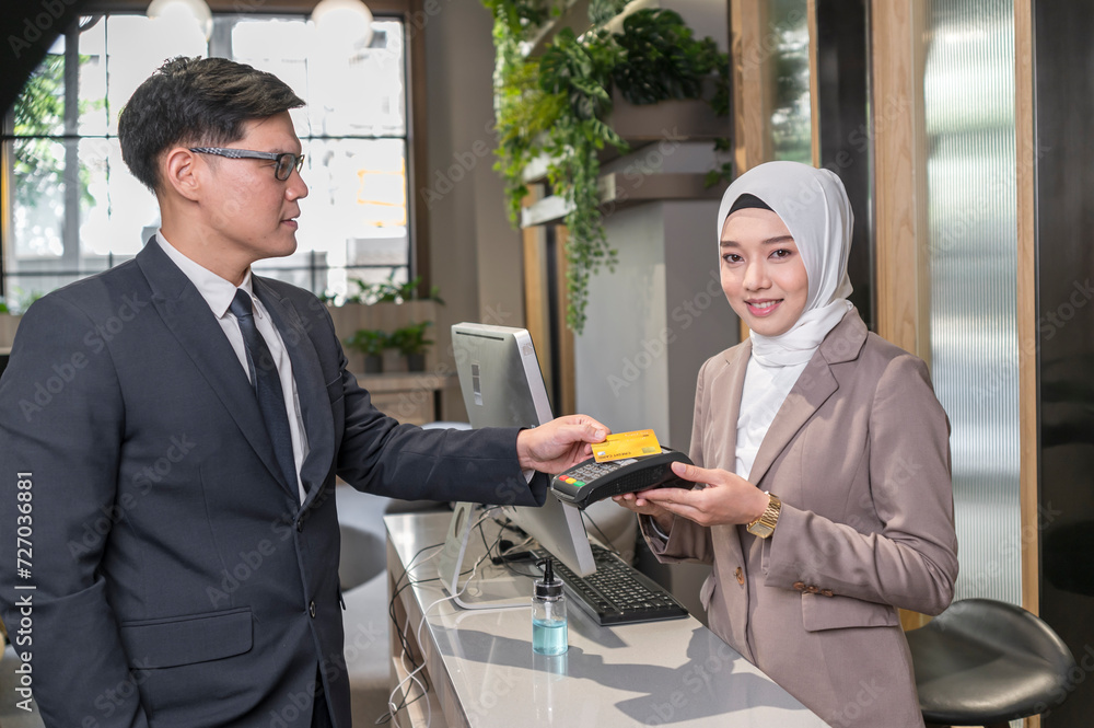 Customer used wireless credit card at cashier restaurant counter with smily service - financial technology and cashless concept