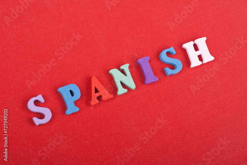 SPANISH word on red background composed from colorful abc alphabet block wooden letters, copy space for ad text. Learning english concept.