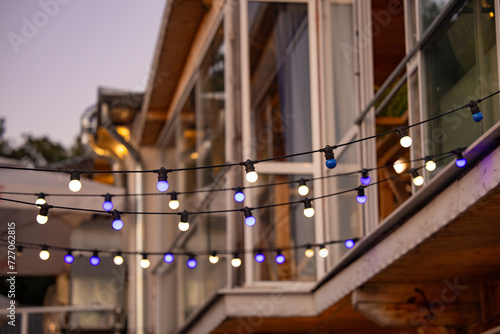 Decoration colorful lights over a street with windows. Colorful Christmas lights for a celebration in a restaurant street in Bulgaria.