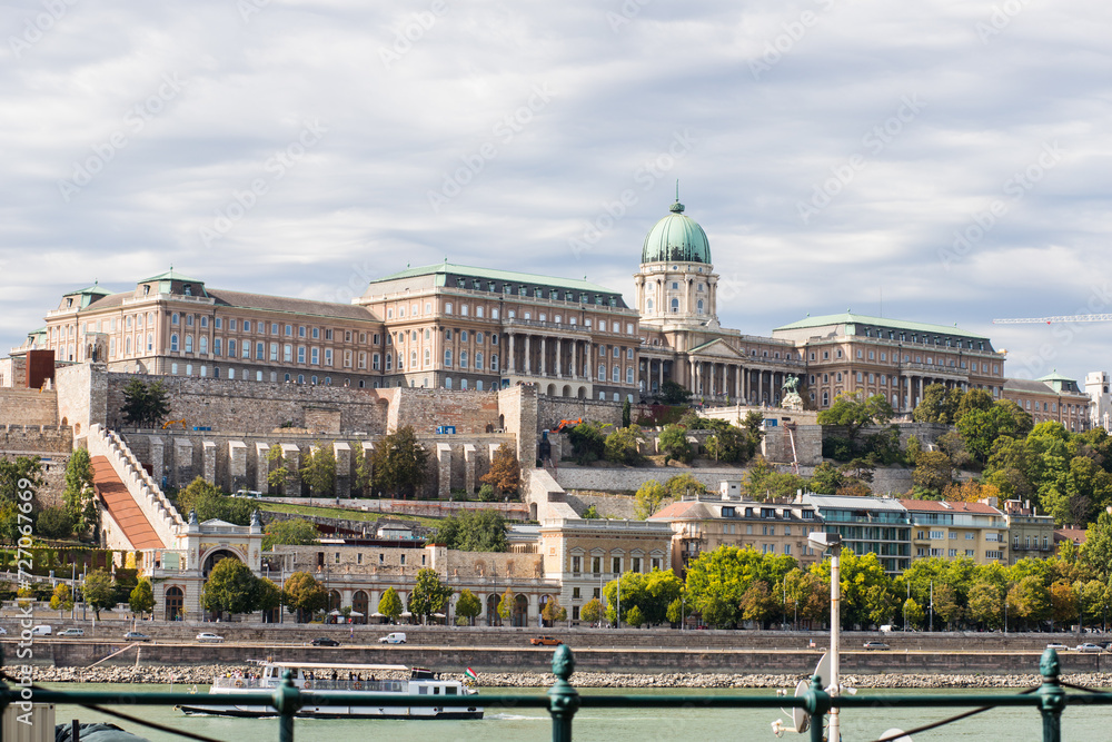 Building on a slope on the banks of the Danube River. Long building with one dome. Buildings on several levels on the mountain.