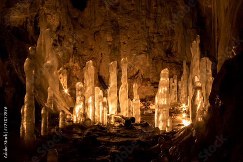 Ice stalagmites in a cave illuminated by candles photo