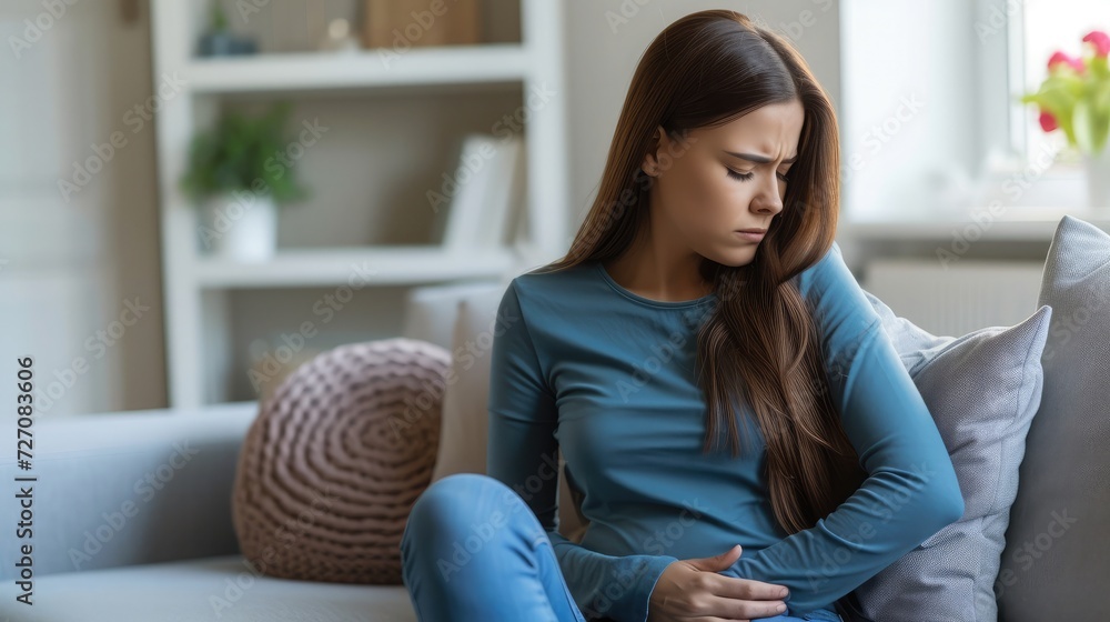 Woman having stomach ache, bending and holding hands on belly, discomfort from menstrual cramps Woman having stomach ache, bending and holding hands on belly, discomfort from menstrual cramps