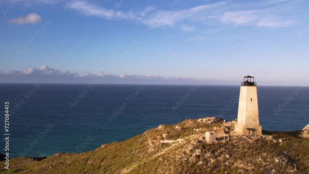 Old lighthouse on a rugged coastline overlooking the sea, clear sky Old lighthouse on a rugged coastline overlooking the sea, clear sky