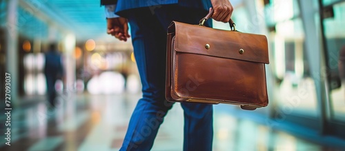 A businessman walks holding his bag