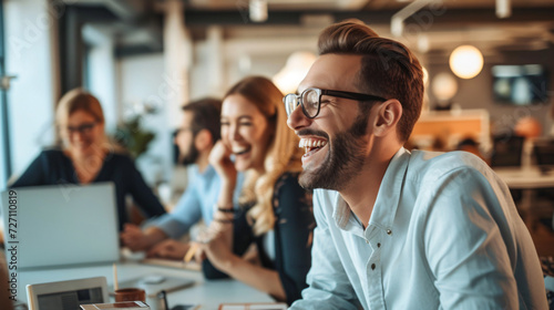 A group of diverse colleagues share a delightful moment of laughter in a laid-back office, enhancing team spirit and fostering a pleasant work environment.