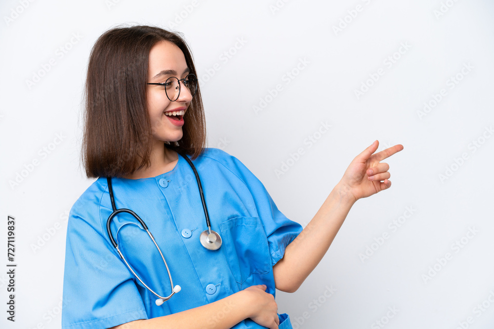 Young nurse Ukrainian woman isolated on white background pointing finger to the side and presenting a product Young nurse Ukrainian woman isolated on white background pointing finger to the side and presenting a product