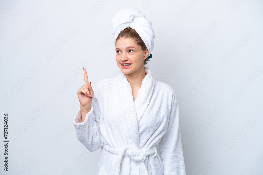 Teenager Russian girl in a bathrobe isolated on white background pointing up a great idea