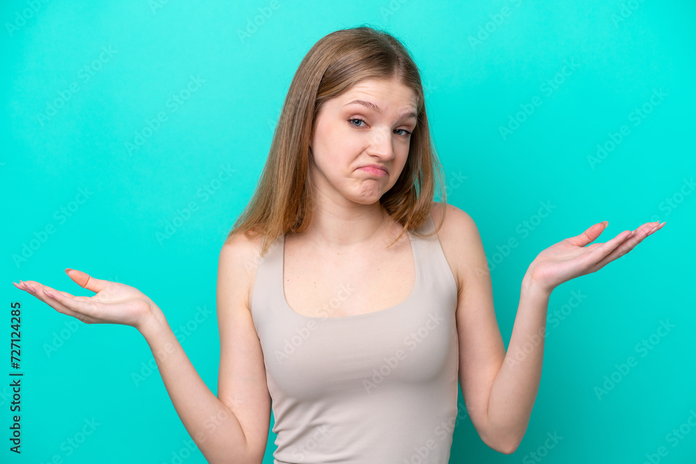 Fototapeta premium Teenager Russian girl isolated on blue background having doubts while raising hands