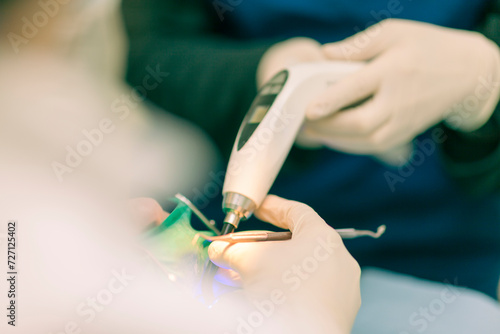 Detail of a dentist performing surgery with anesthesia on a patient for root canal treatment and regeneration. No people are recognizable.