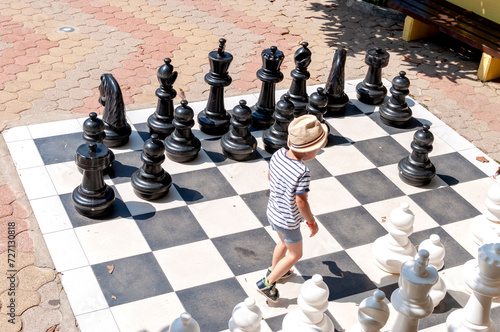 The boy is playing big chess