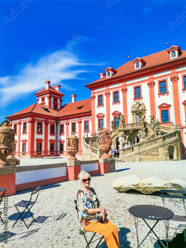 Senior woman on excursion in Troja Palace is a Baroque palace located in Troja, photo