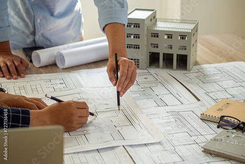Professional cartographers working with cadastral map at table, closeup photo