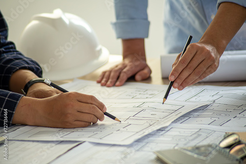 Professional cartographers working with cadastral map at table, closeup