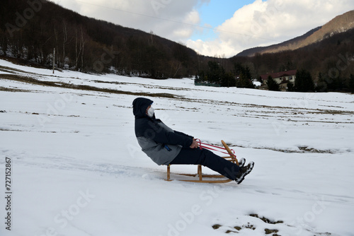 Obraz na płótnie Grandfather slide on the sledge in the winter snow w salonie