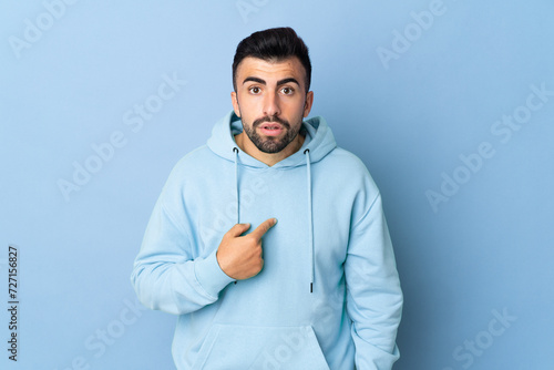 Caucasian man over isolated blue background pointing to oneself © luismolinero