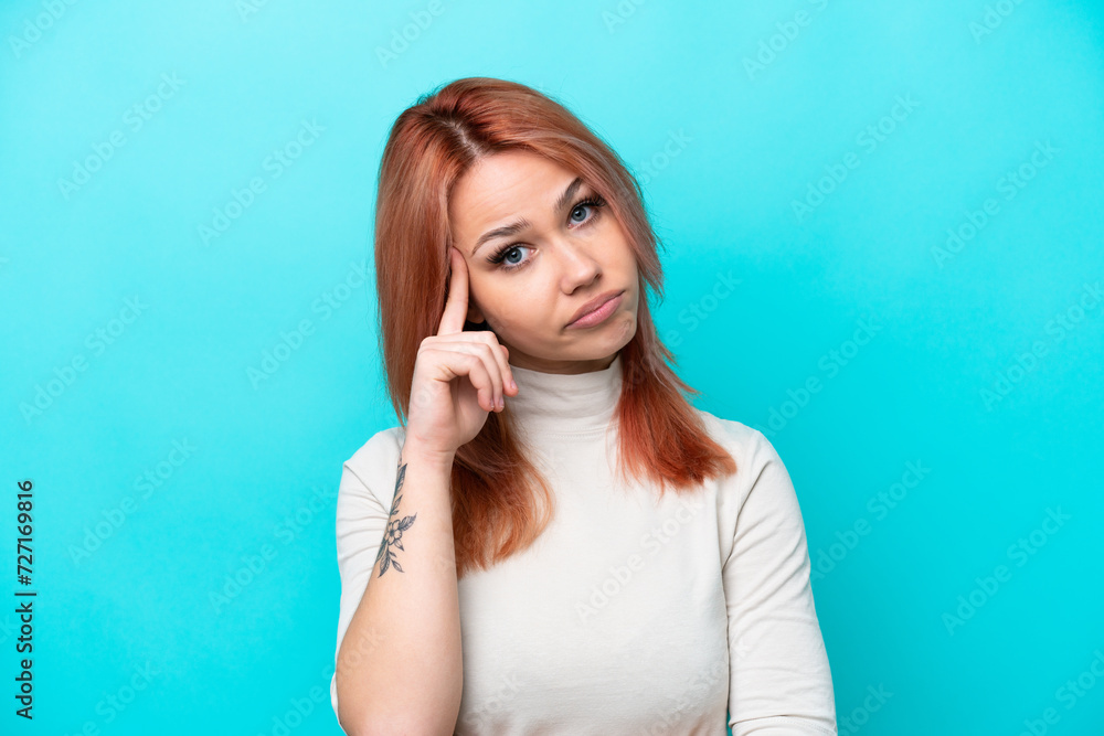 Young Russian woman isolated on blue background thinking an idea Young Russian woman isolated on blue background thinking an idea