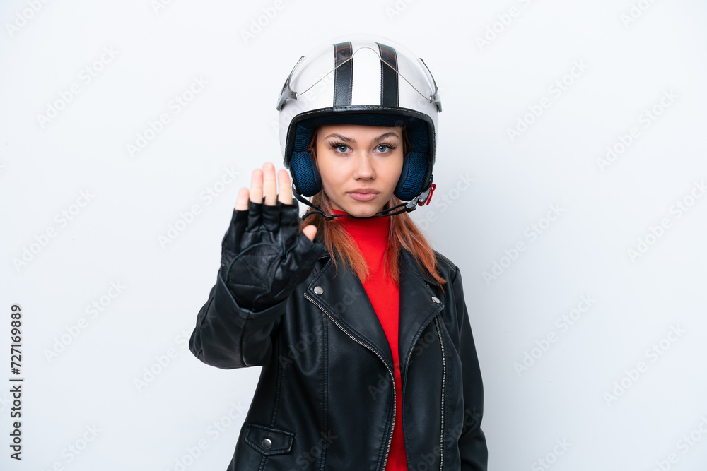 Young Russian girl with a motorcycle helmet isolated on white background making stop gesture Young Russian girl with a motorcycle helmet isolated on white background making stop gesture