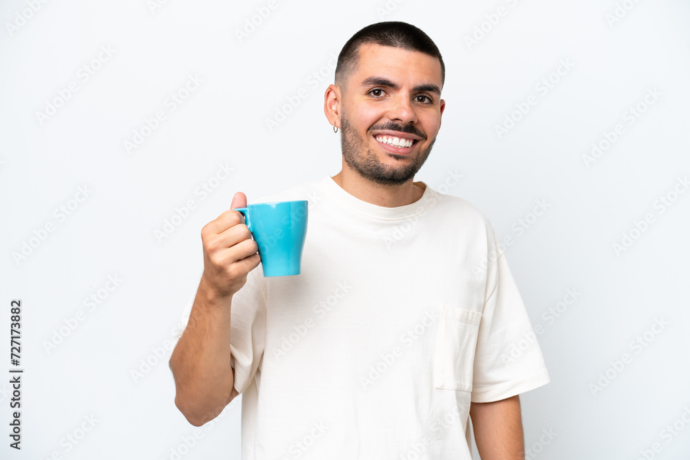 Young caucasian man holding cup of coffee isolated white background smiling a lot Young caucasian man holding cup of coffee isolated white background smiling a lot