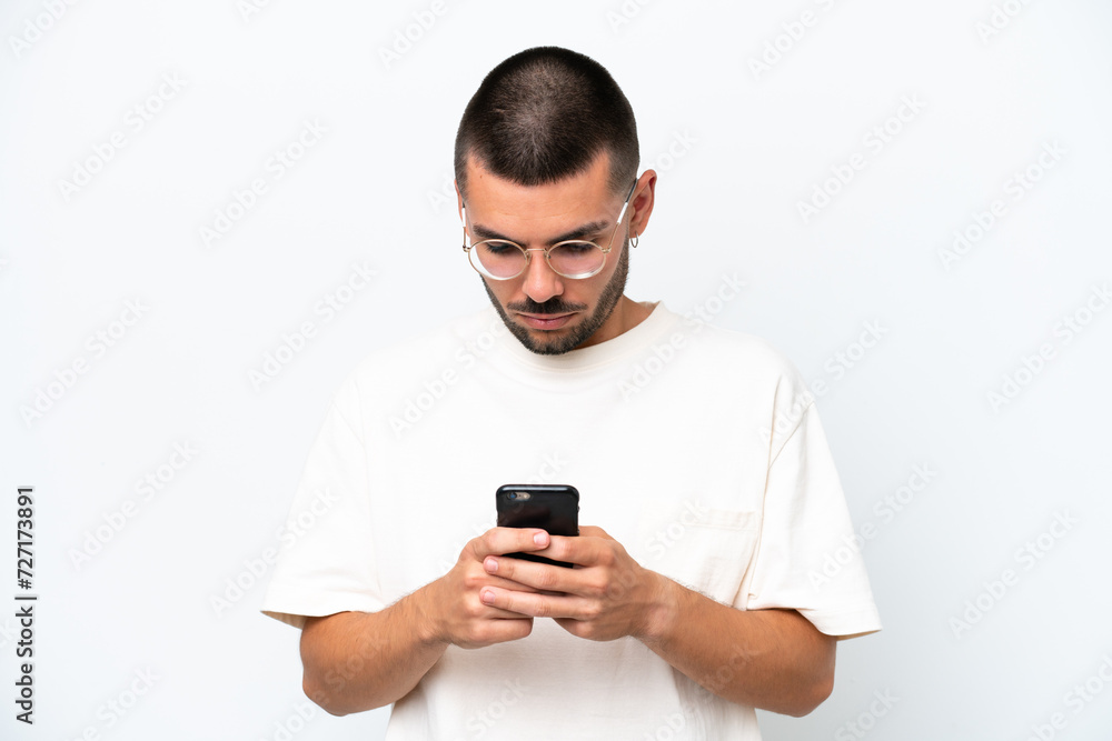 Young caucasian man isolated on white background using mobile phone Young caucasian man isolated on white background using mobile phone