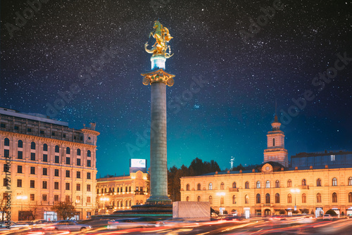 Tbilisi  Georgia  Eurasia. Amazing Bold Bright Blue Starry Sky Gradient Above Liberty Monument Depicting St George Slaying The Dragon And Tbilisi City Hall In Freedom Square In City Center.