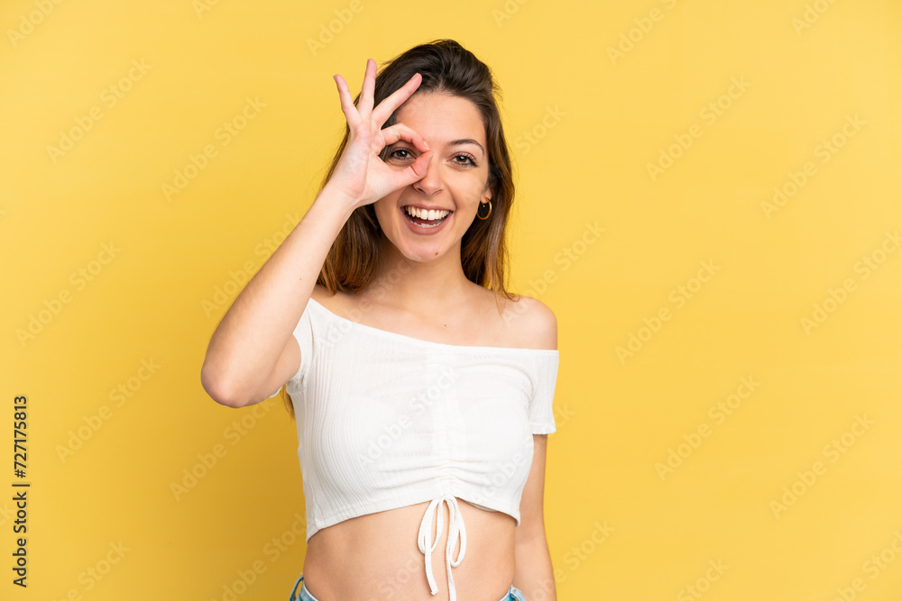 Fototapeta premium Young caucasian woman isolated on yellow background showing ok sign with fingers