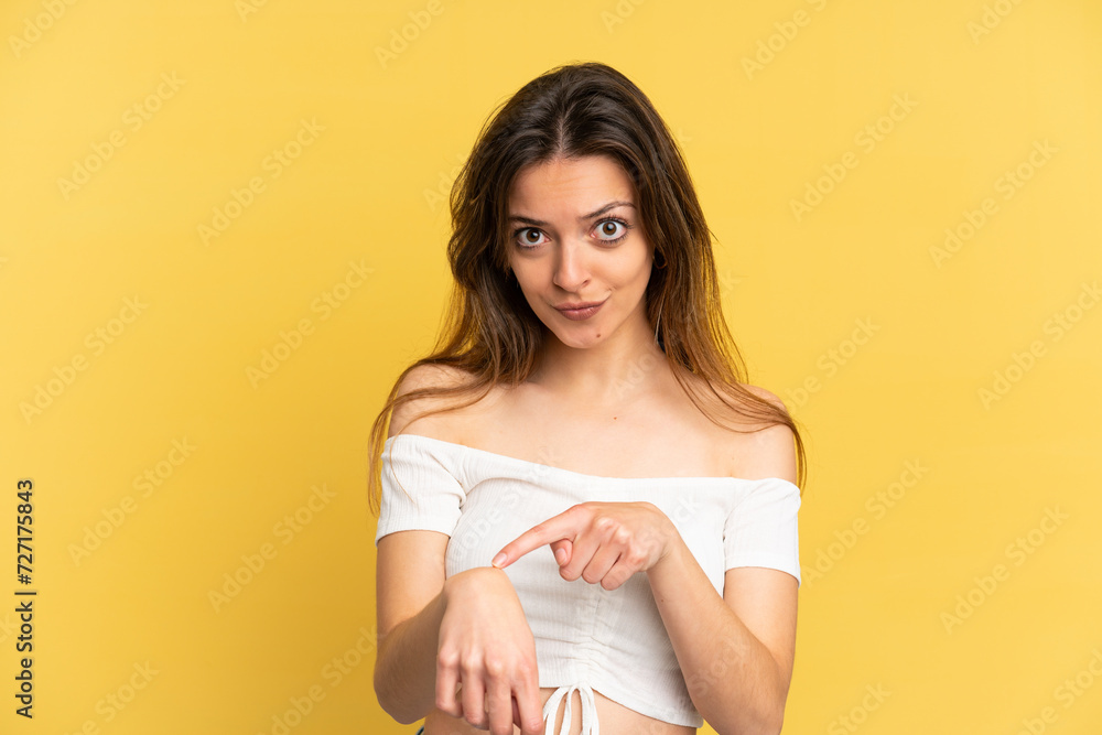 Young caucasian woman isolated on yellow background making the gesture of being late Young caucasian woman isolated on yellow background making the gesture of being late