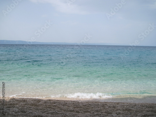 Scenic shining view of the clear water of Adriatic Sea on a sunny summer day. Colorful natural fresh background for creative illustration with shiny blur effect. Bright nautical scape beauty closeup