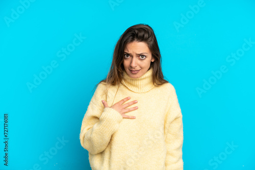 Young caucasian woman isolated on blue background pointing to oneself