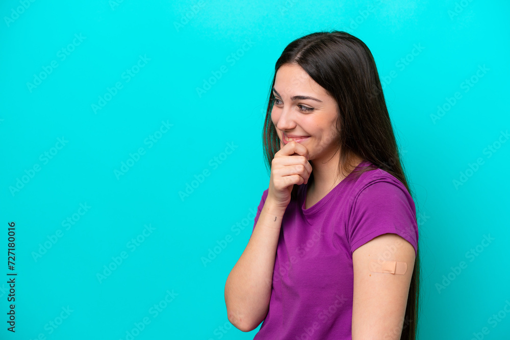 Young girl with band-aids isolated on blue background thinking an idea and looking side Young girl with band-aids isolated on blue background thinking an idea and looking side