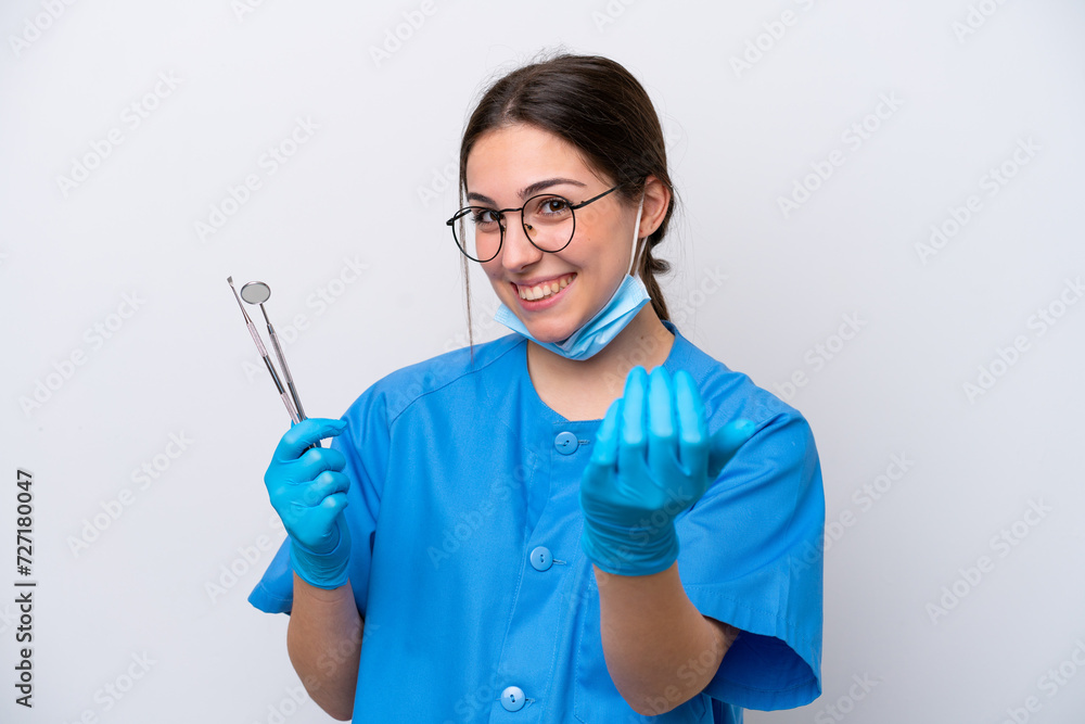 Dentist caucasian woman holding tools isolated on white background inviting to come with hand. Happy that you came