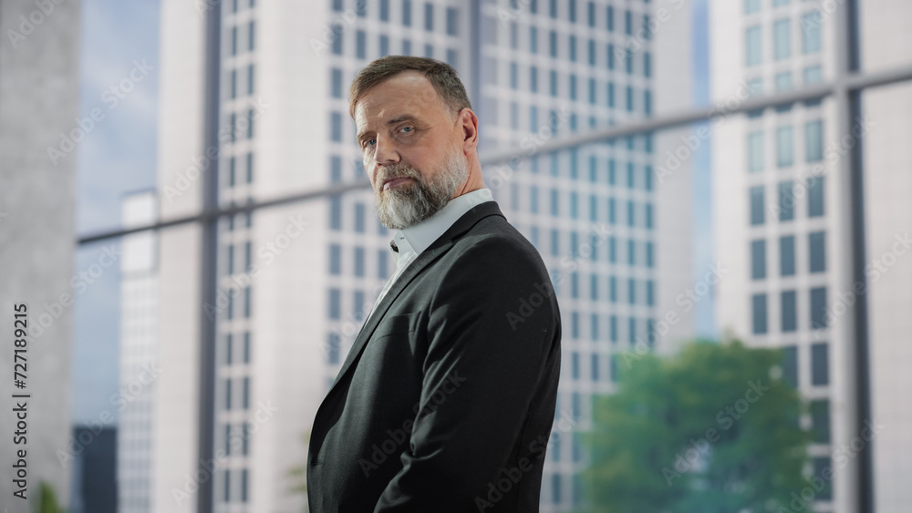 Portrait of a Handsome Businessman Wearing a Suit, Posing in a Modern Office Building. Successful Middle Aged Male Smiling, Looking at Camera. Business, Financial or Corporate Concept Portrait of a Handsome Businessman Wearing a Suit, Posing in a Modern Office Building. Successful Middle Aged Male Smiling, Looking at Camera. Business, Financial or Corporate Concept