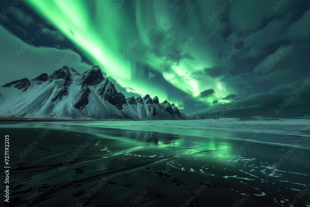 Stunning green aurora borealis over snowy mountain ridge in Iceland.