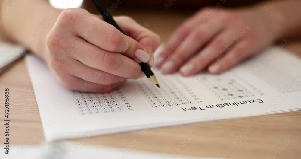 Student hand testing in control exam with pencil drawing on answer sheets. Accepting multiple choice for assessment in exam Student hand testing in control exam with pencil drawing on answer sheets. Accepting multiple choice for assessment in exam