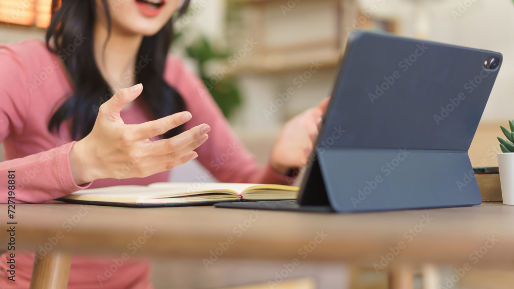 Obraz premium Young businesswoman explaining business project with partners while meeting in video call on tablet