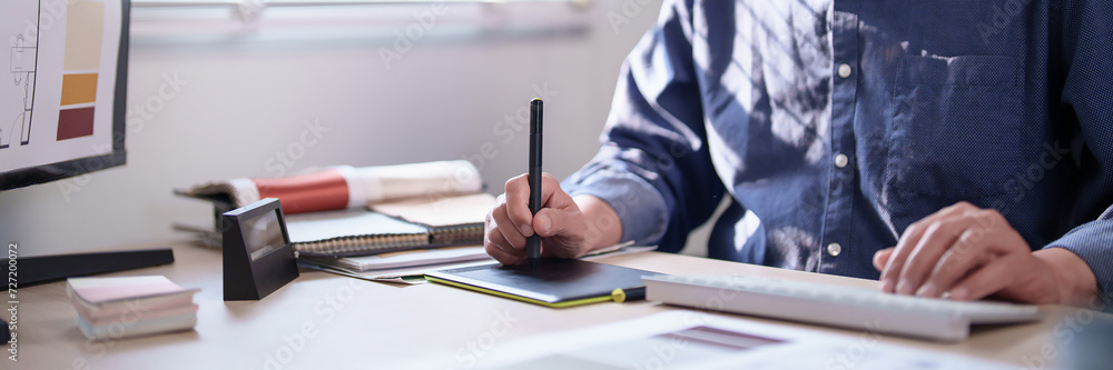 Interior designer senior man writing in digital tablet and typing data ...
