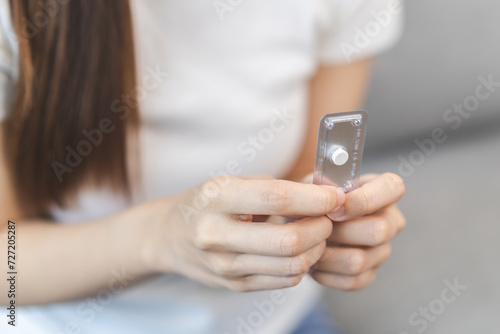 Emergency contraception and pregnancy concept asian young woman hand holding birth control pills, hormonal oral contraceptive medicine at home, take pharmaceutical to prevention virus sex disease.