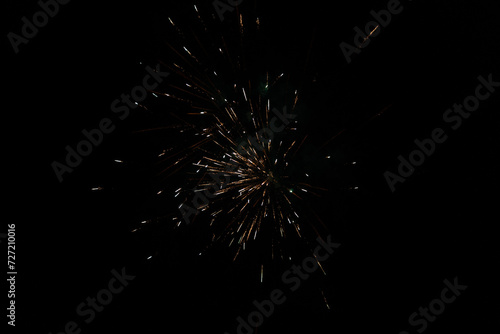 Burst of orange fireworks at night - vibrant orange streaks and sparks - smoke clouds - celebration  new years day  fourth of july  canada day. Taken in Toronto  Canada.