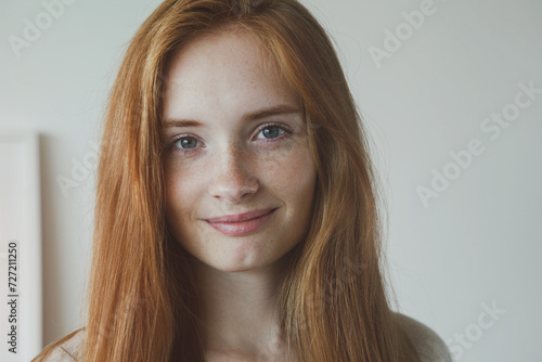 Portrait of beautiful young smiling woman with long red hair