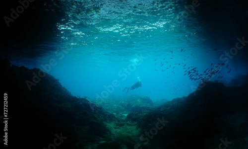 a diver at the entrance to a large cave on the island of Curacao