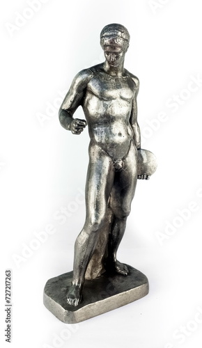 A purchased (widely used) figurine of an ancient discobolus made of aluminum iron in close-up on a white background