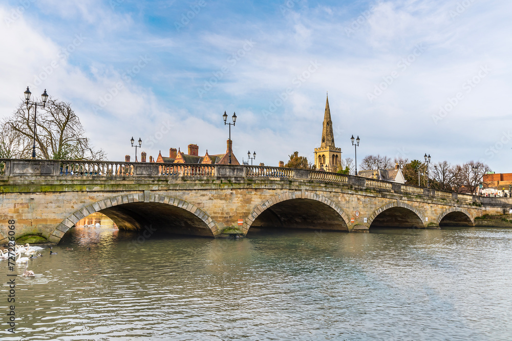 A view from the southern shore along the town bridge over the River Great Ouse in Bedford, UK on a bright sunny day
