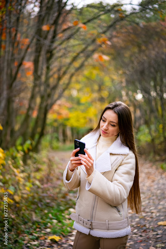 Young woman using her smartphone in the park © Vadim