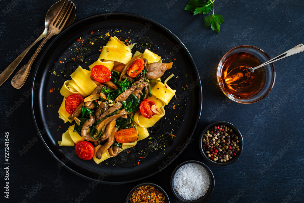 Asian food - fried soy sauce oyster mushrooms with noodles on black table Asian food - fried soy sauce oyster mushrooms with noodles on black table