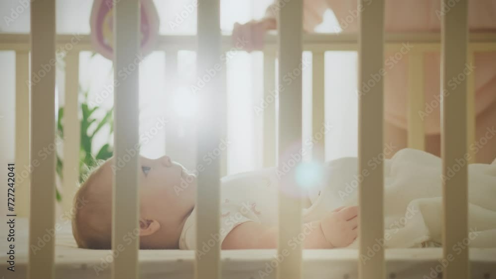 A young modern mother is trying to put her baby to sleep by rocking the