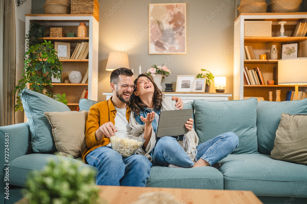 Couple caucasian man and woman sit at home on sofa bed watch movie Couple caucasian man and woman sit at home on sofa bed watch movie
