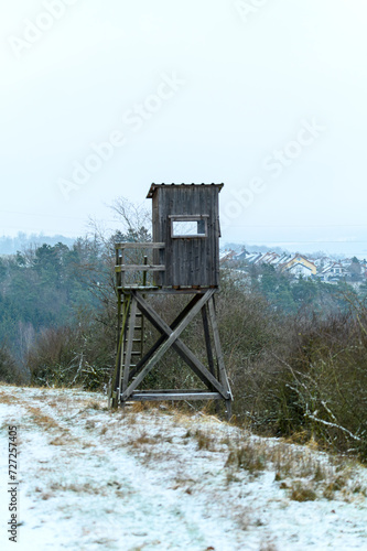 Wooden lookout tower for hunting in the woods and on meadow
