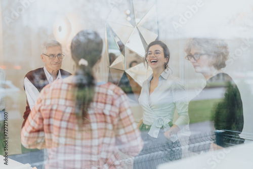 Fotografie Cross generational coworkers in a corporate office collaborating on strategies for business growth and profitability